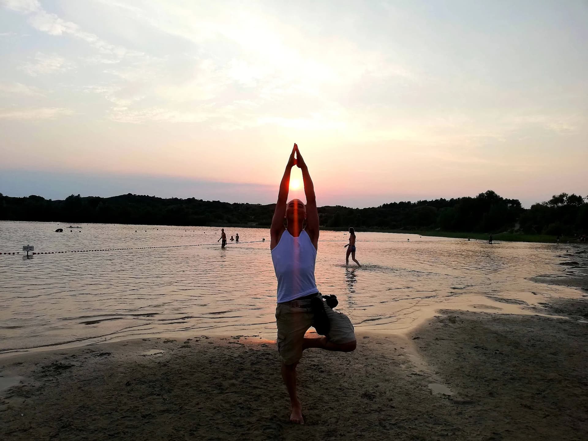 Person doing yoga on a beach at sunset